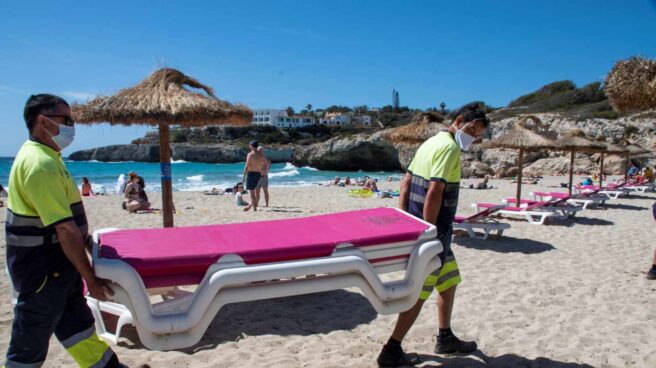 Varios operarios colocan hamacas en la playa de Cala Domingos Gran de Manacor.