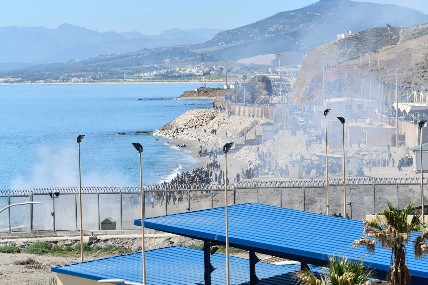 Agentes lanzan gas hacia los inmigrantes que tratan de cruzar la frontera hacia Ceuta desde Marruecos.