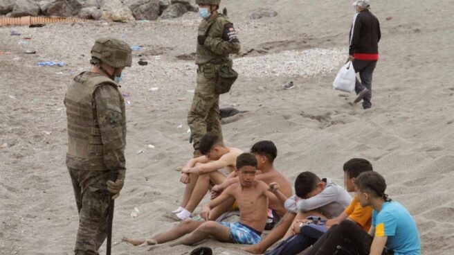 Un soldado, junto a un grupo de menores que cruzaron ilegalmente la frontera con Ceuta.