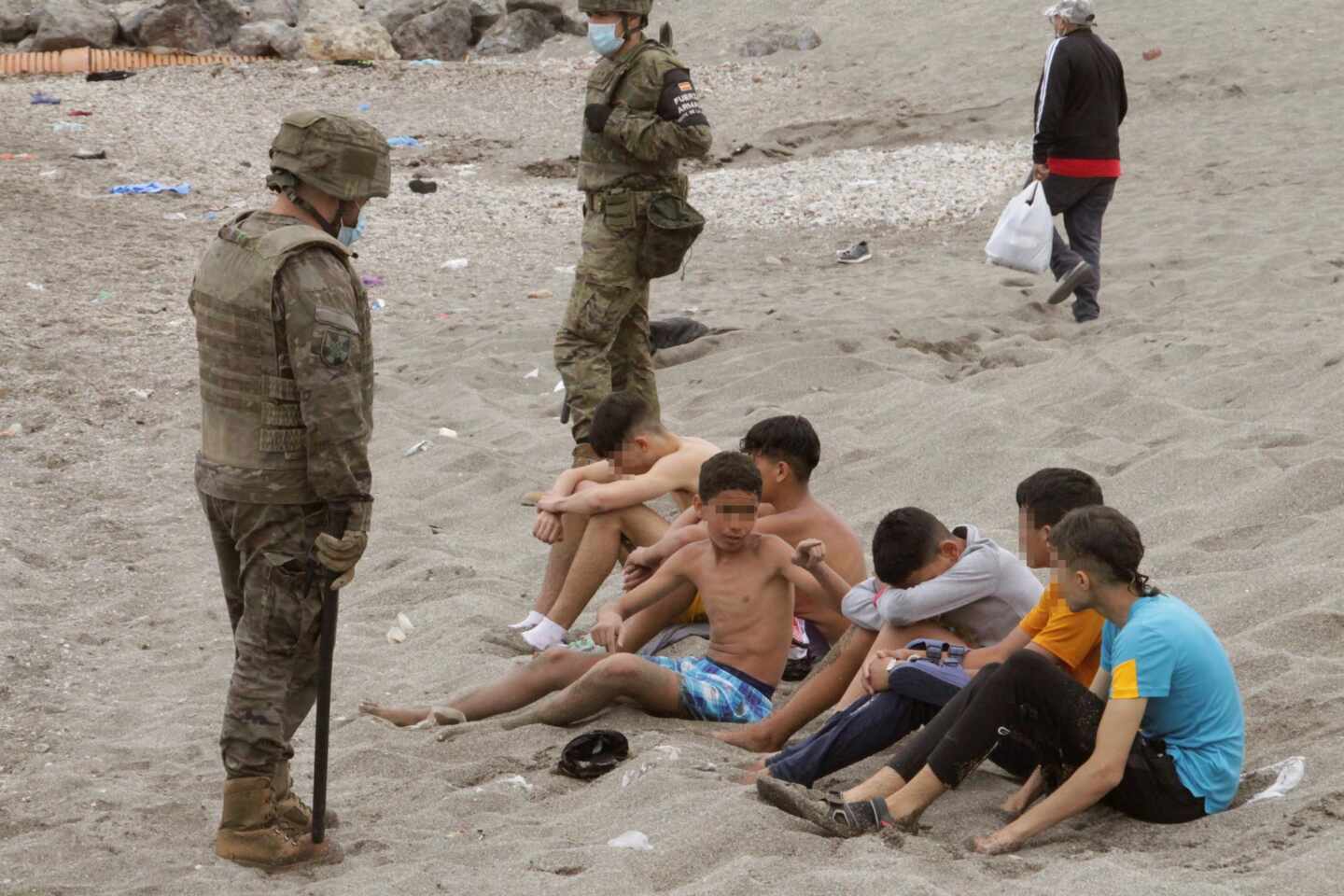 Un soldado, junto a un grupo de menores que cruzaron ilegalmente la frontera con Ceuta.