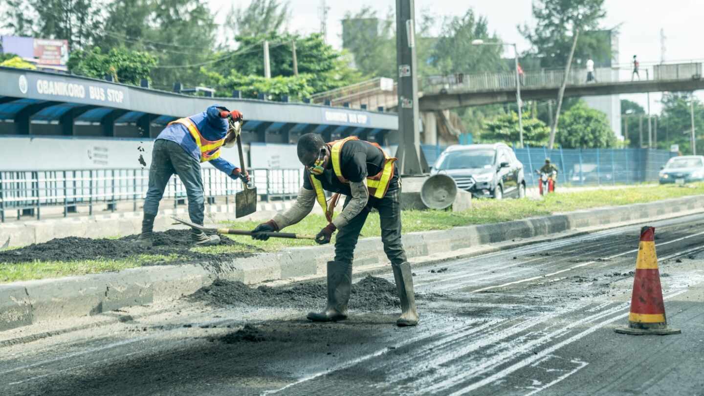 Dos hombres trabajan en la construcción de una carretera en Lagos.