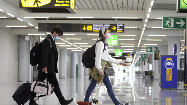 Dos turistas en el aeropuerto de Palma (Baleares) con un perrito.