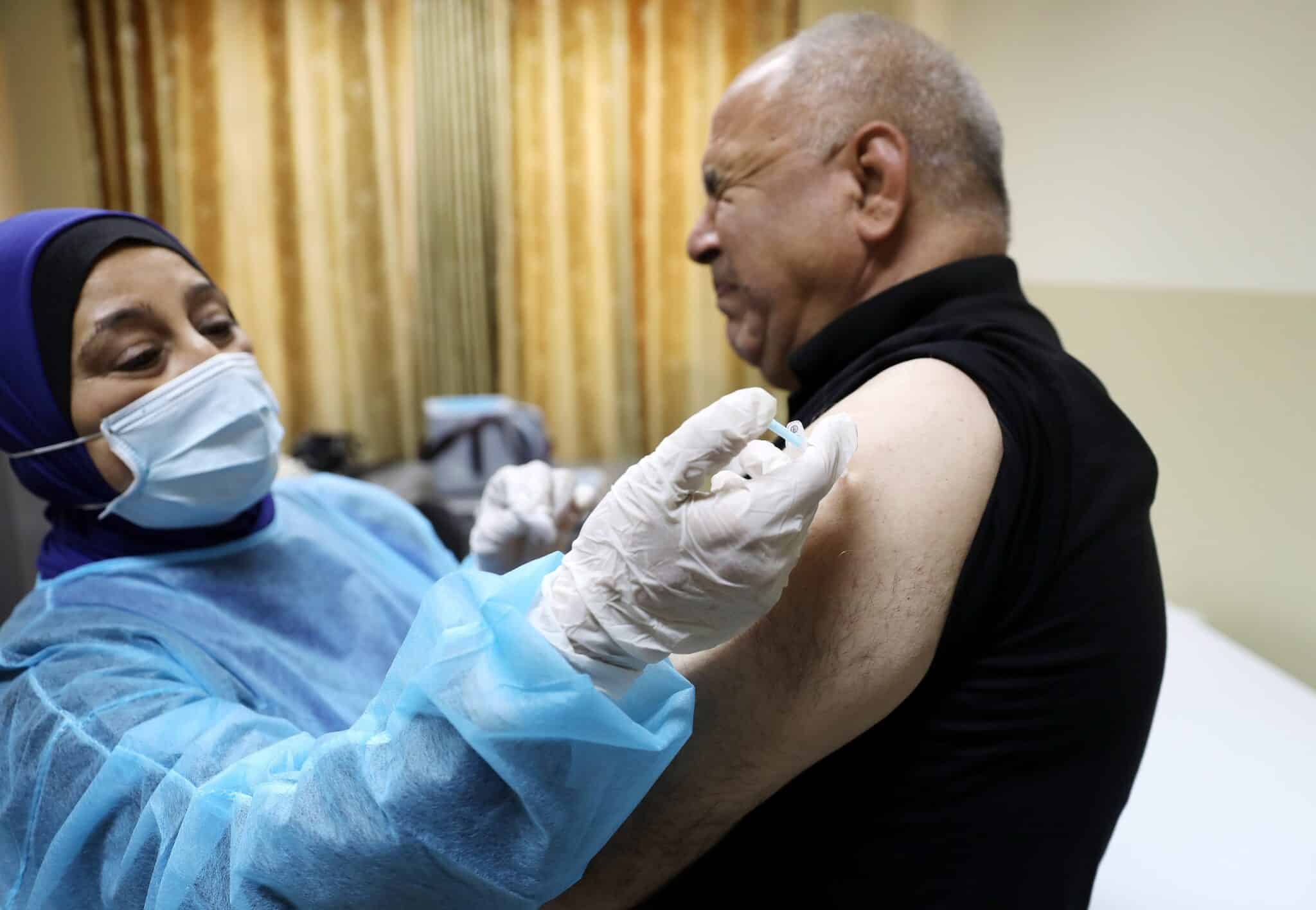 Un trabajador médico palestino recibe la vacuna de Pfizer contra el Covid-19.