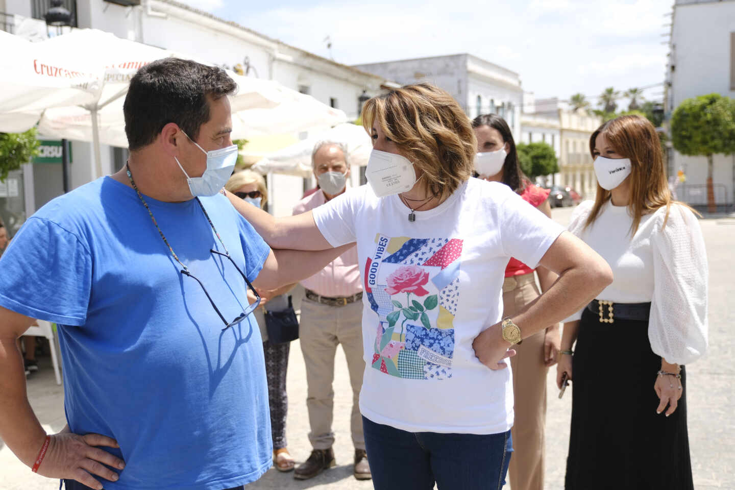 Díaz conversa con un militante del PSOE-A con una camiseta que llama a las "buenas vibraciones"