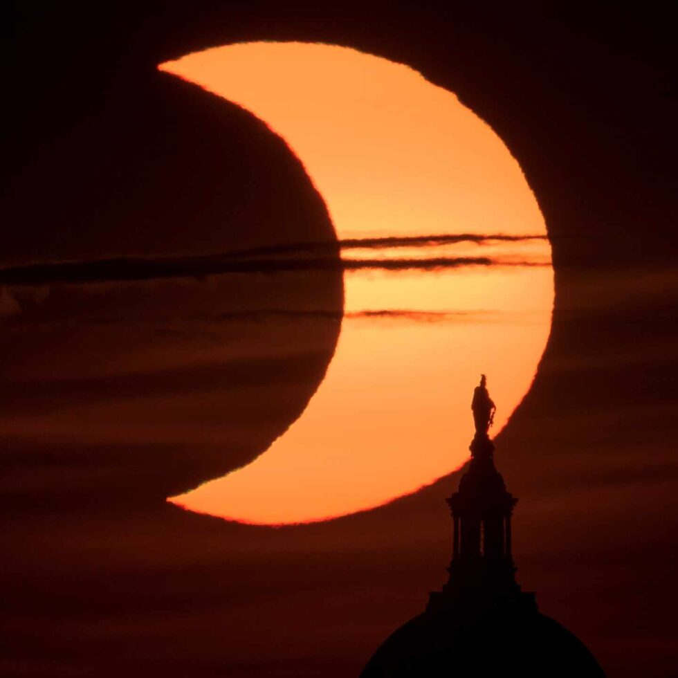 El eclipse, con la estatua de la Libertad del Capitolio de Washington en primer plano