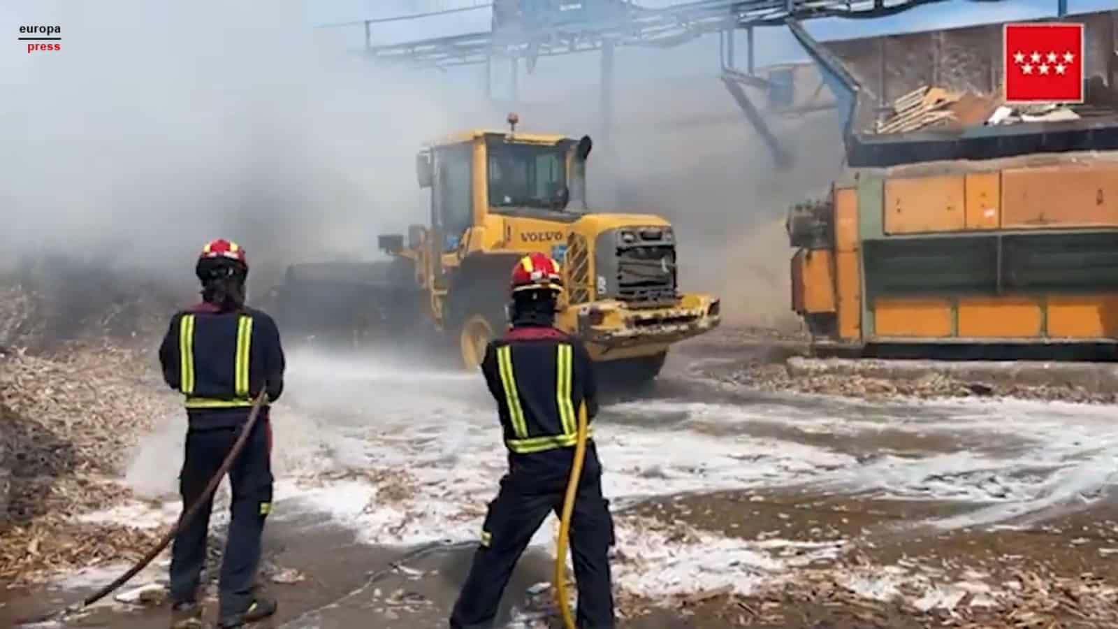 Bomberos trabajan en la extinción de un incendio de material para reciclaje almacenado en Alcalá (Madrid)