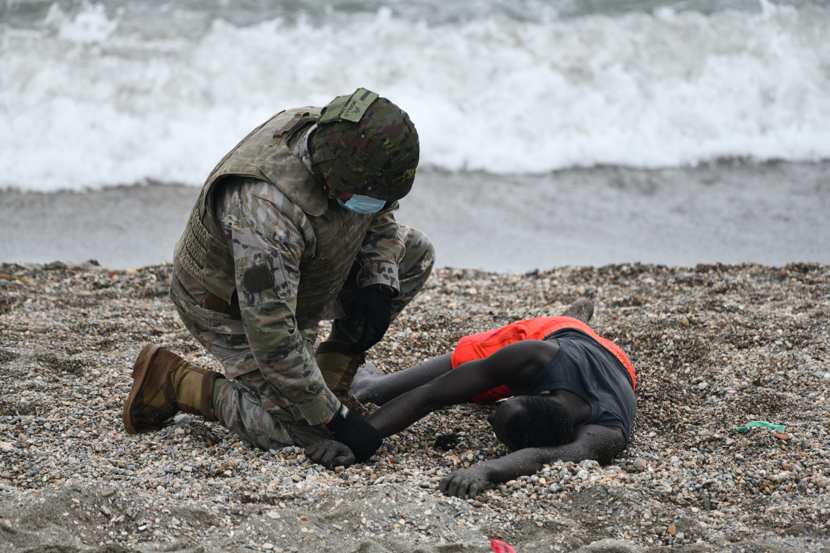 Un militar español atiende a un migrante en la costa de Ceuta