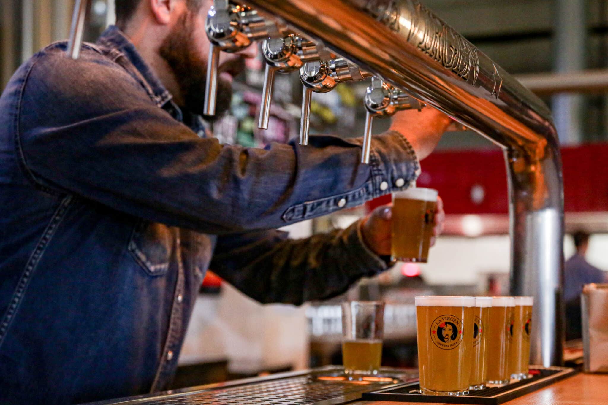 Un camarero tirando cerveza en la fábrica de cerveza artesanal 'La Virgen', en Las Rozas.