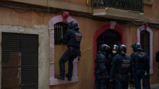 Agentes de Mossos d'Esquadra entran en casa de un vecino de Barcelona desahuciado.