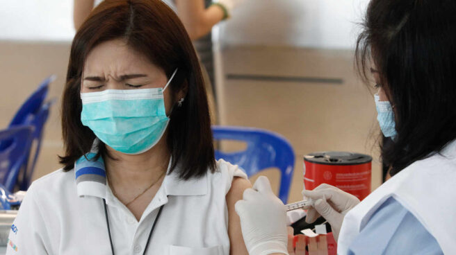 Una sanitaria administra una dosis de la vacuna Sinovac a un empleado del aeropuerto de Bangkok (Tailandia).