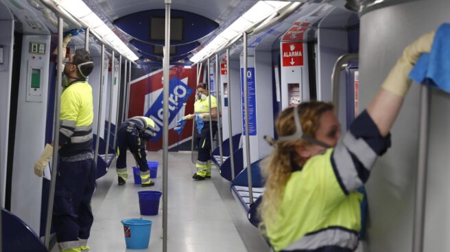 Varios operarios limpian el interior de un tren del Metro de Madrid.