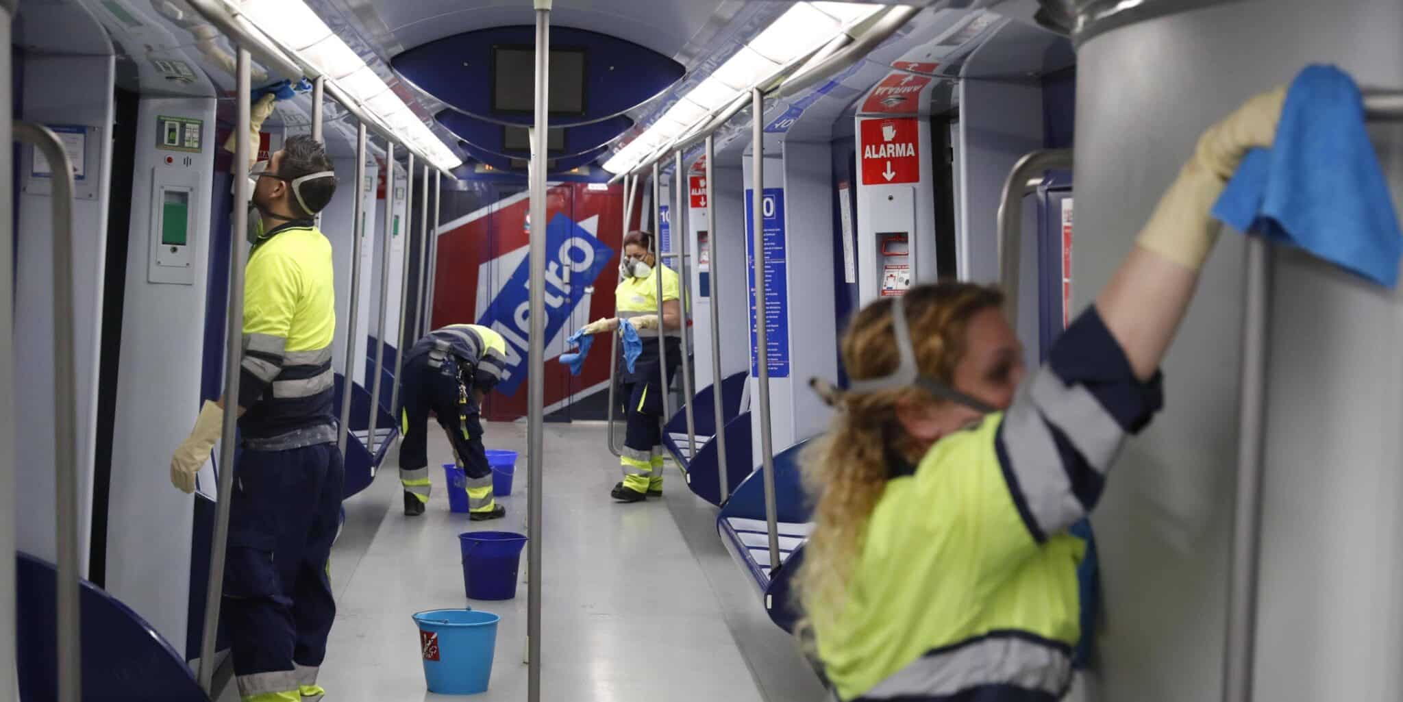 Varios operarios limpian el interior de un tren del Metro de Madrid.