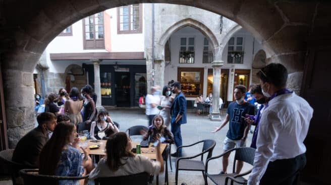 Jóvenes en una mesa de una terraza de un bar.