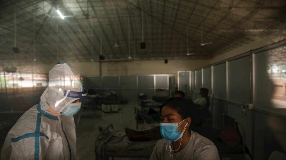 Un sanitario atiende a una paciente en un centro de aislamiento Covid en Katmandú (Nepal).