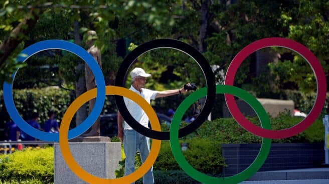 Un hombre se hace una foto delante de los aros olímpicos en Tokio 2020 2021