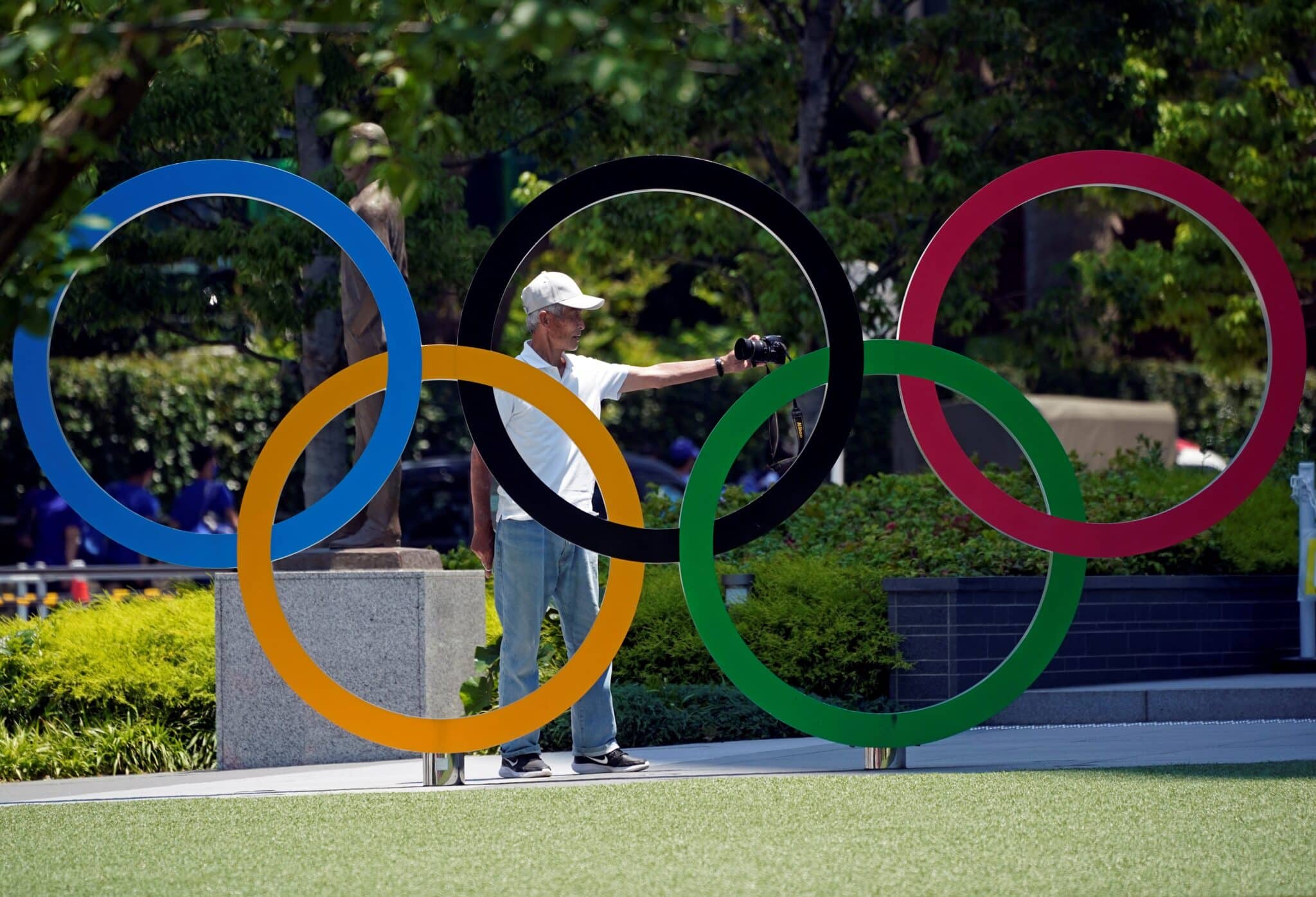 Un hombre se hace una foto delante de los aros olímpicos en Tokio 2020 2021