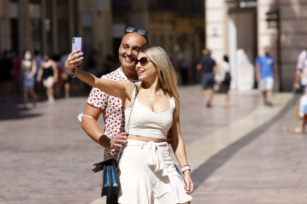 Dos jóvenes se hacen una foto sin mascarilla en la calle Larios