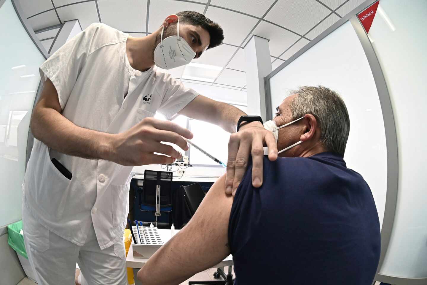 Un sanitario vacuna contra el coronavirus a un hombre en el hospital de Alcalá de Henares en Madrid.