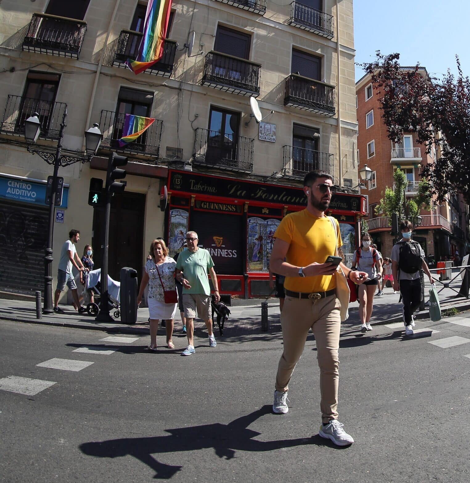 Personas paseando por Madrid con y sin mascarillas