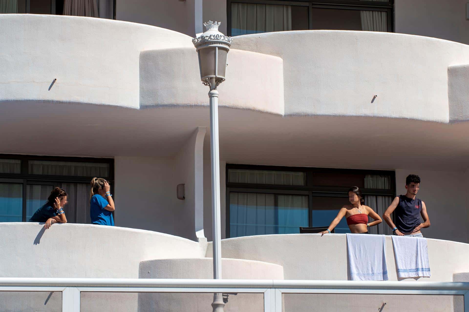 Varios estudiantes, asomados a las terrazas del hotel de Mallorca en el que permanecen aislados.