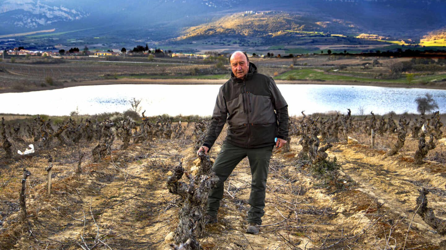 Florentino Martinez Monje, posa con el complejo lagunar con Laguardia (Álava) al fondo, rodeado de viñedos.