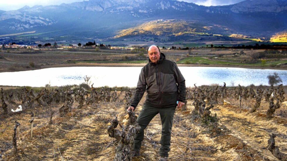 Florentino Martinez Monje, posa con el complejo lagunar con Laguardia (Álava) al fondo, rodeado de viñedos.