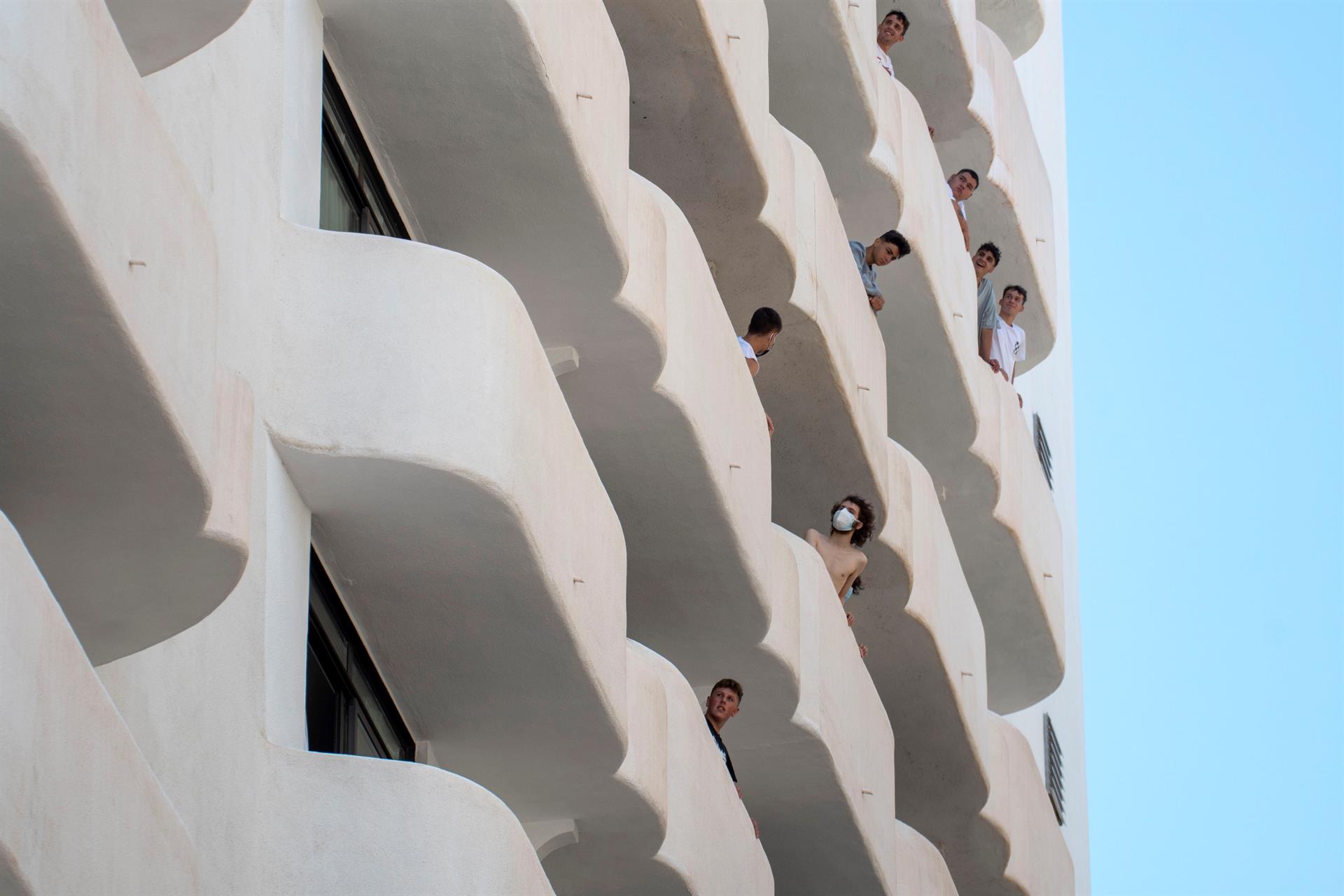 Estudiantes asomados a los balcones del hotel en el que permanecen en cuarentena en Mallorca tras el megabrote vinculado a los viajes de fin de curso.
