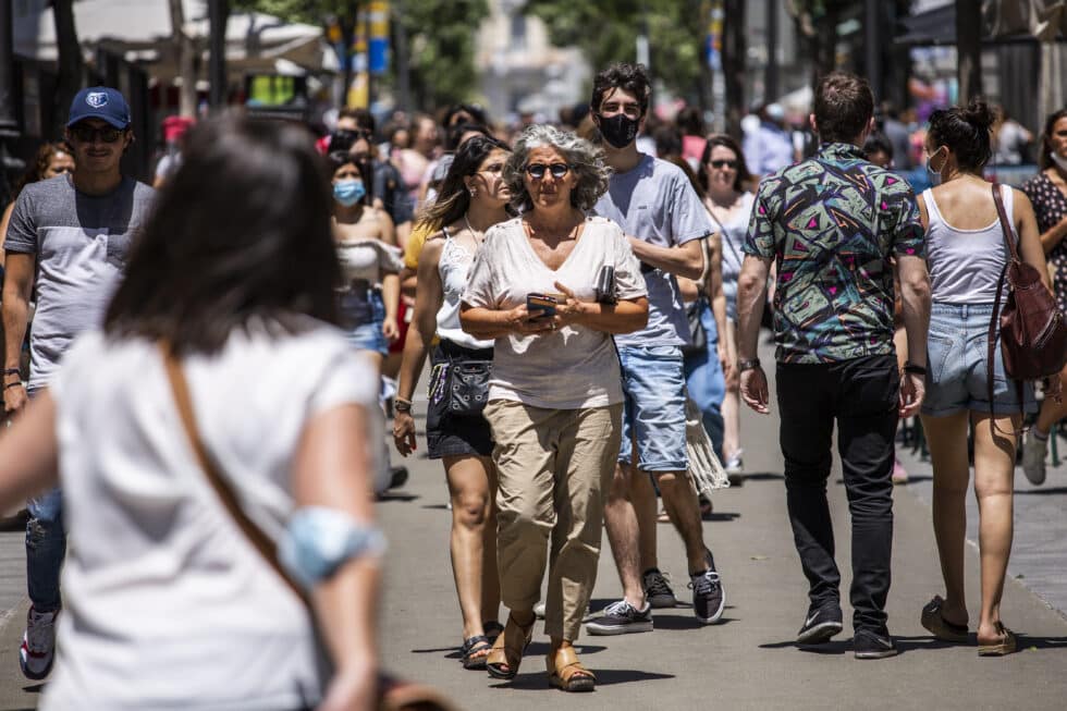Una mujer pasea sin mascarilla por el centro de Madrid, durante el primer día en el que no es obligado el uso de la mascarilla en exteriores.