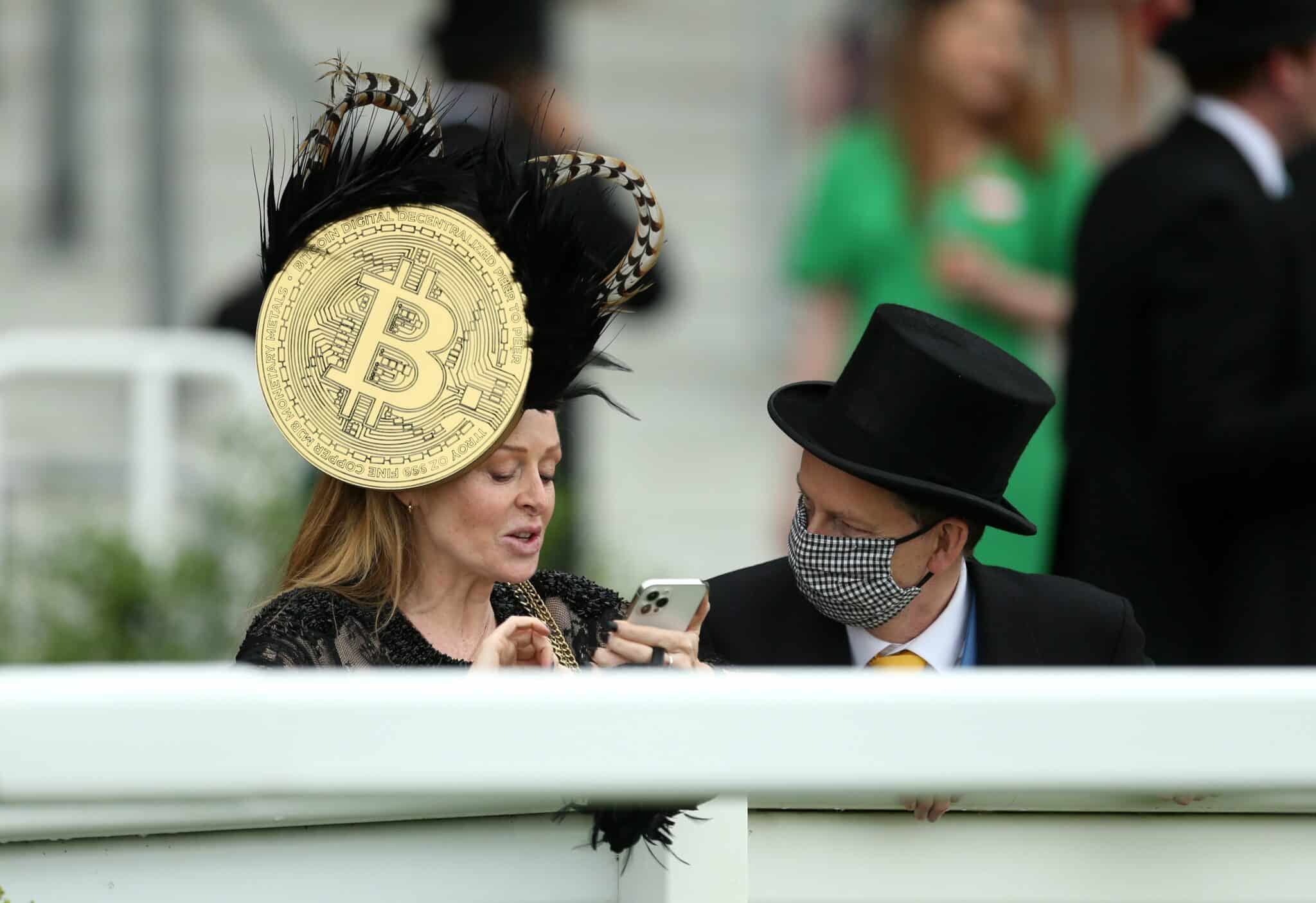 Una mujer, con una pamela con el símbolo del Bitcoin, en las carreras de caballos de Ascot.