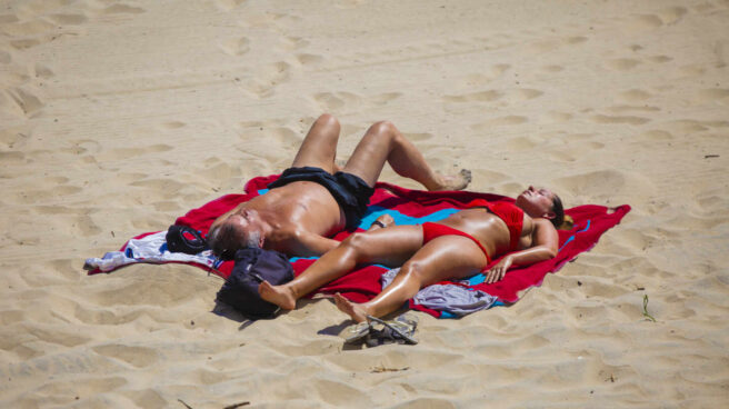 Una pareja toma el sol en la playa de Matalascañas. Una pareja toma el sol en la playa de Matalascañas.