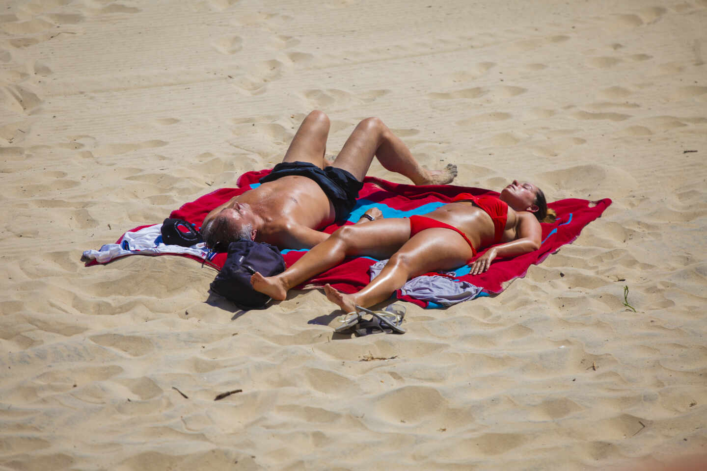 Una pareja toma el sol en la playa de Matalascañas.