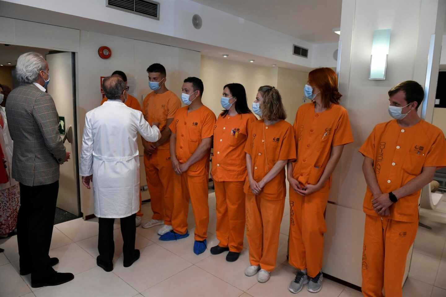 El consejero Enrique Ruiz Escudero saluda a un grupo de sanitarios en el cierre de un hotel medicalizado.