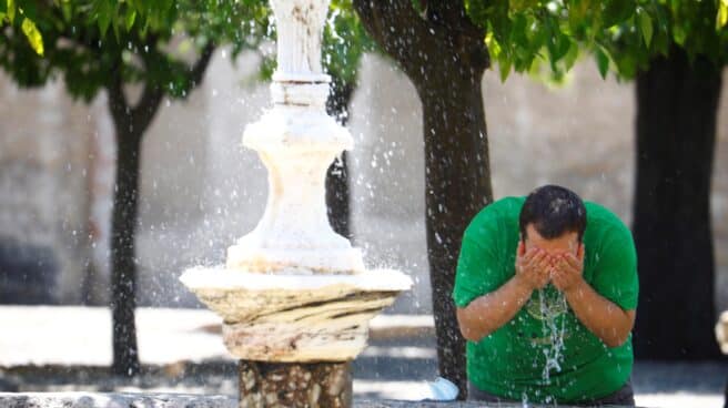 Un hombre se refresca en Córdoba.