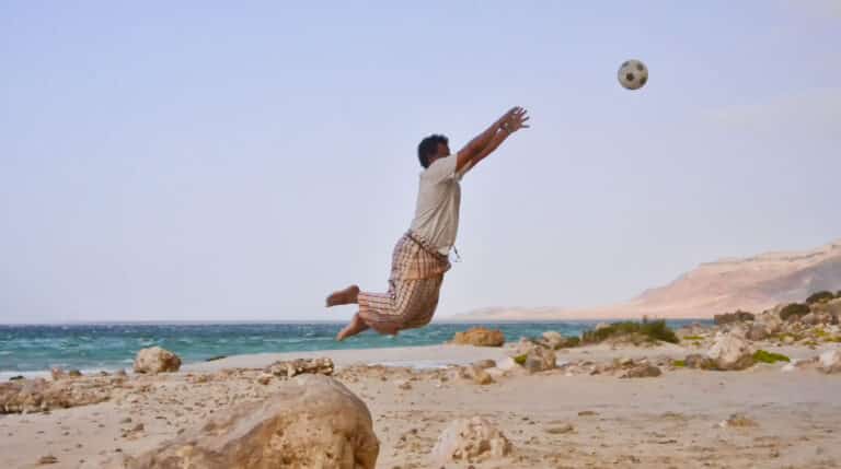 Un vecino de la isla juega al fútbol en la playa. Rod Waddington