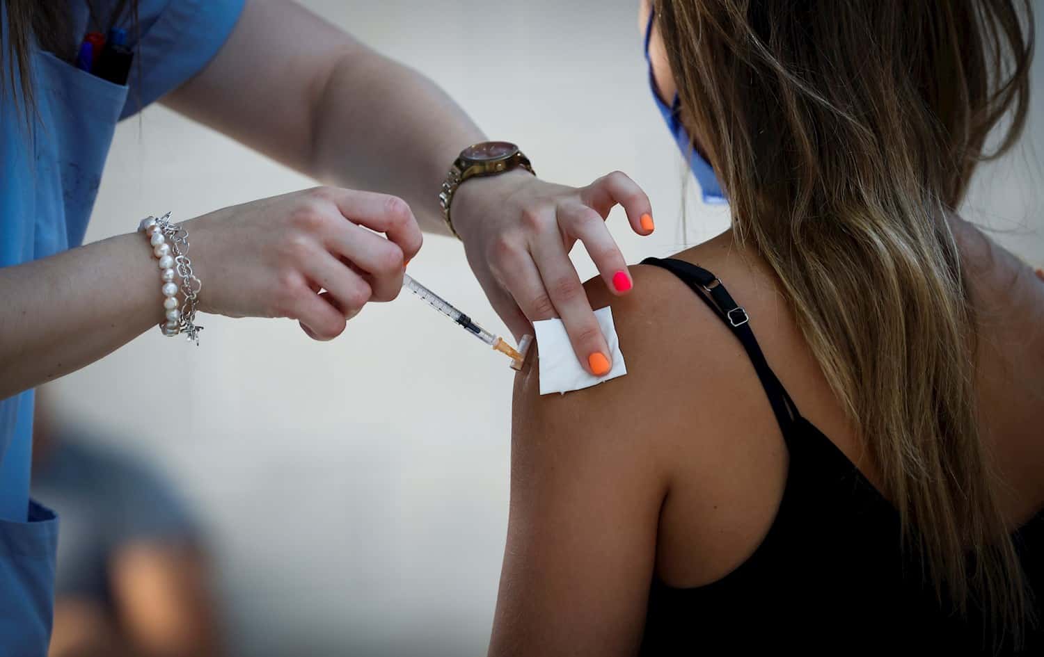 Una joven recibe una vacuna contra el Covid.