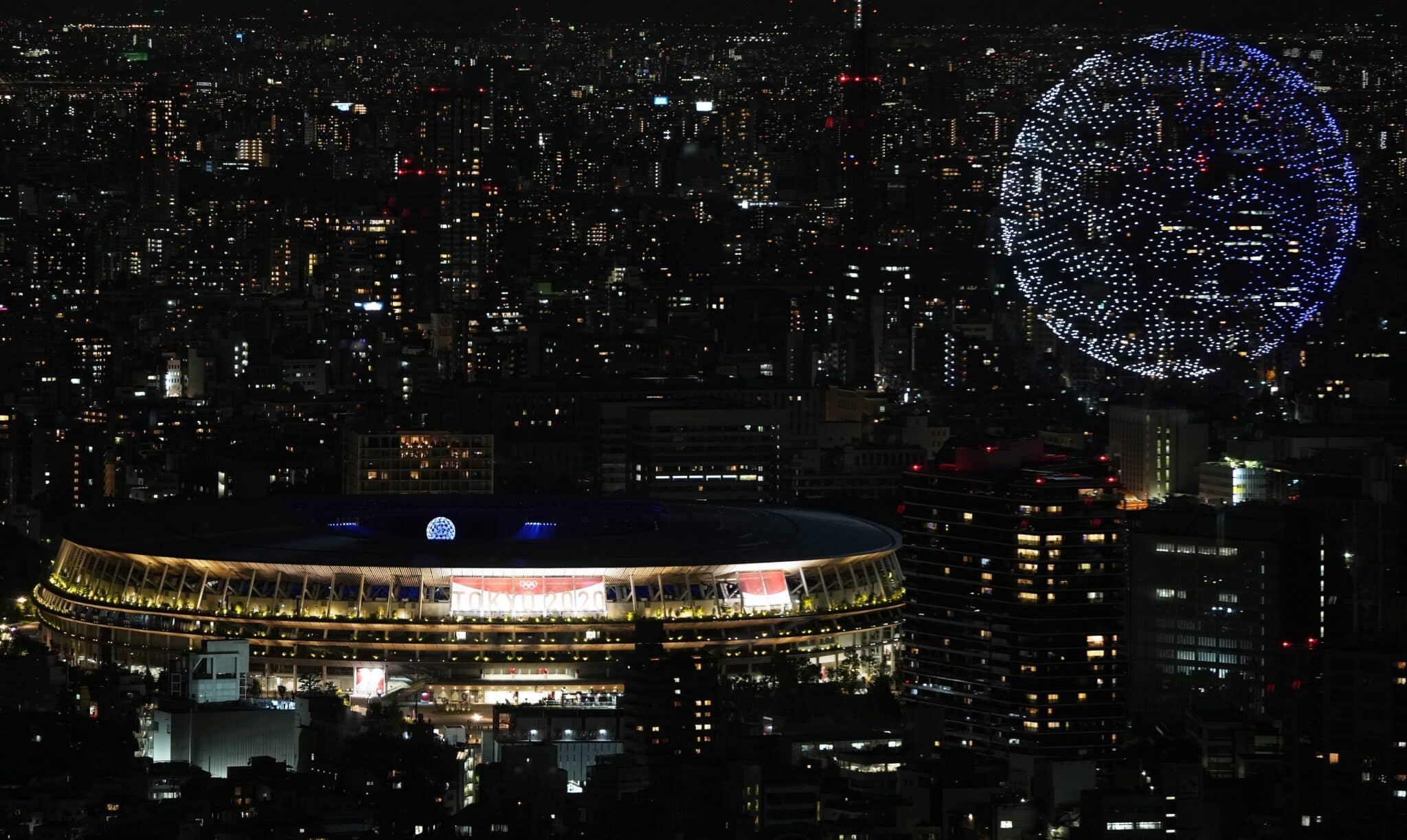 Imagen de la bola del mundo que han formado cientos de drones encima del Estadio Olímpico