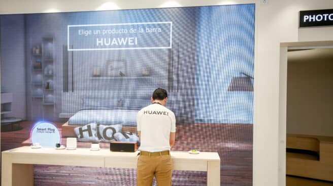 Un empleado del Espacio Huawei de Madrid, ordena algunos de los productos de los expositores, el día de su apertura.