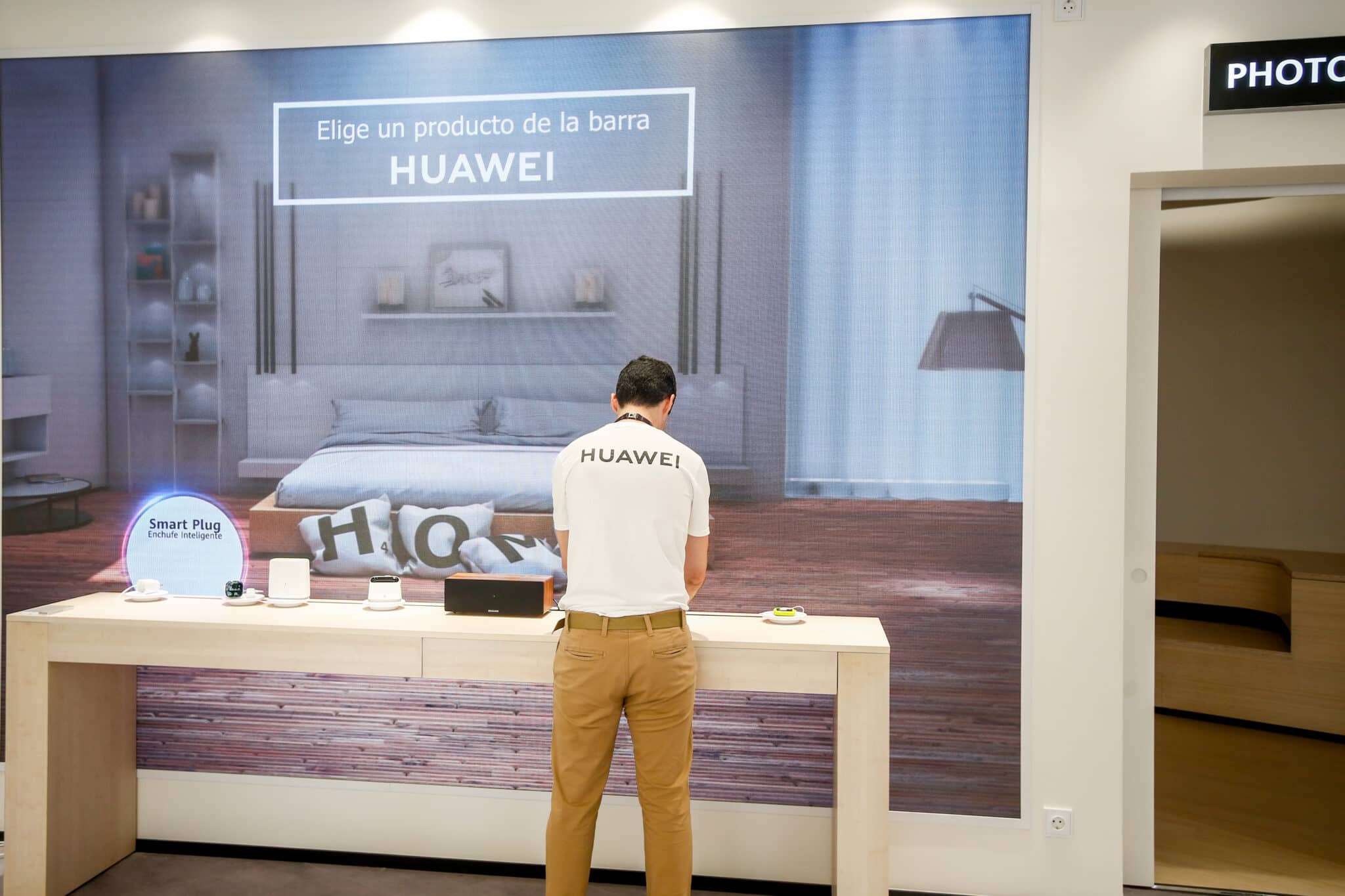 Un empleado del Espacio Huawei de Madrid, ordena algunos de los productos de los expositores, el día de su apertura.