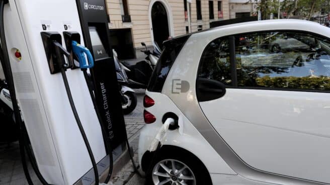 Un coche híbrido se carga en un punto de recarga de batería en Madrid.