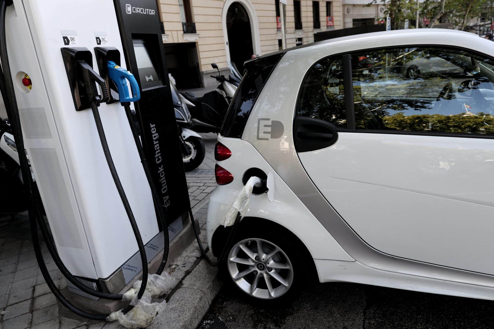 Un coche híbrido se carga en un punto de recarga de batería en Madrid.