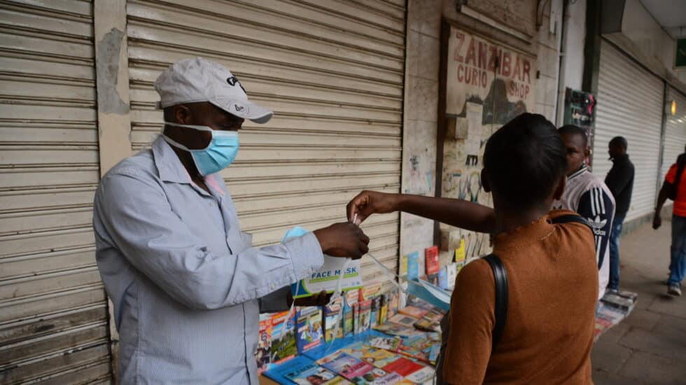 Una mujer compra una mascarilla en una calle de Nairobi, Kenia.