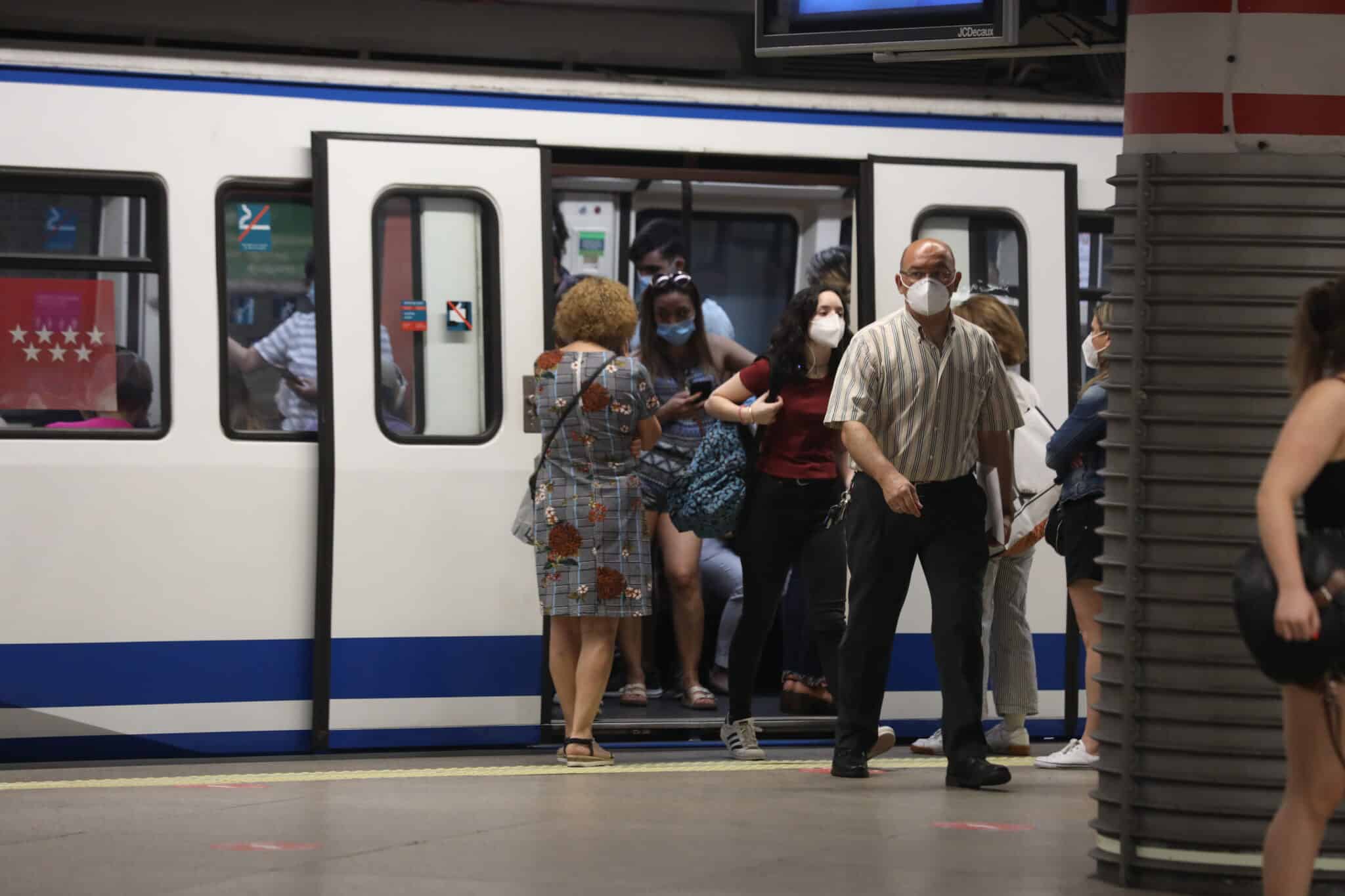 Pasajeros con mascarilla salen de un vagón en la estación de Metro de Atocha.