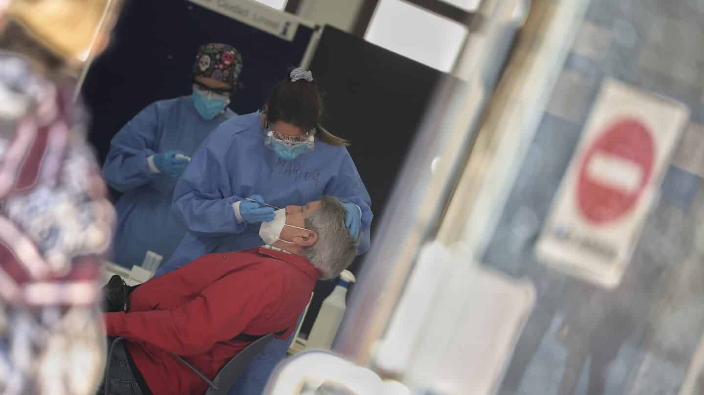 Una sanitaria toma muestras a un hombre para realizar un test de antígenos.