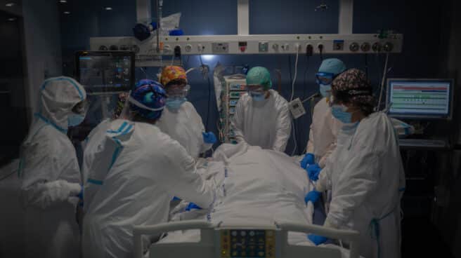 Trabajadores sanitarios protegidos atienden a un paciente en la UCI del Hospital del Mar, en Barcelona.