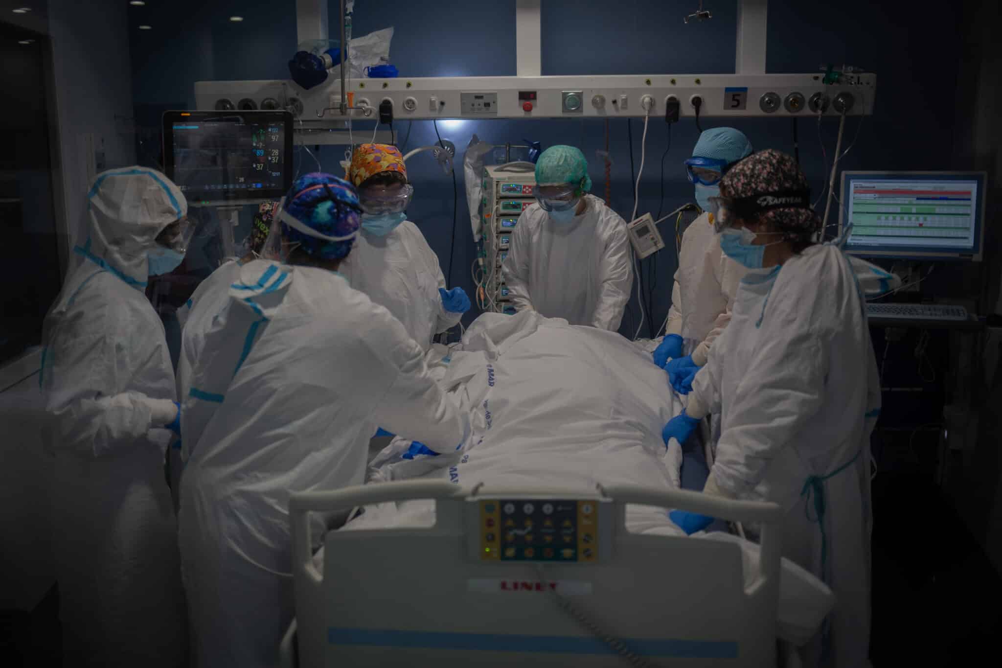 Trabajadores sanitarios protegidos atienden a un paciente en la UCI del Hospital del Mar, en Barcelona.