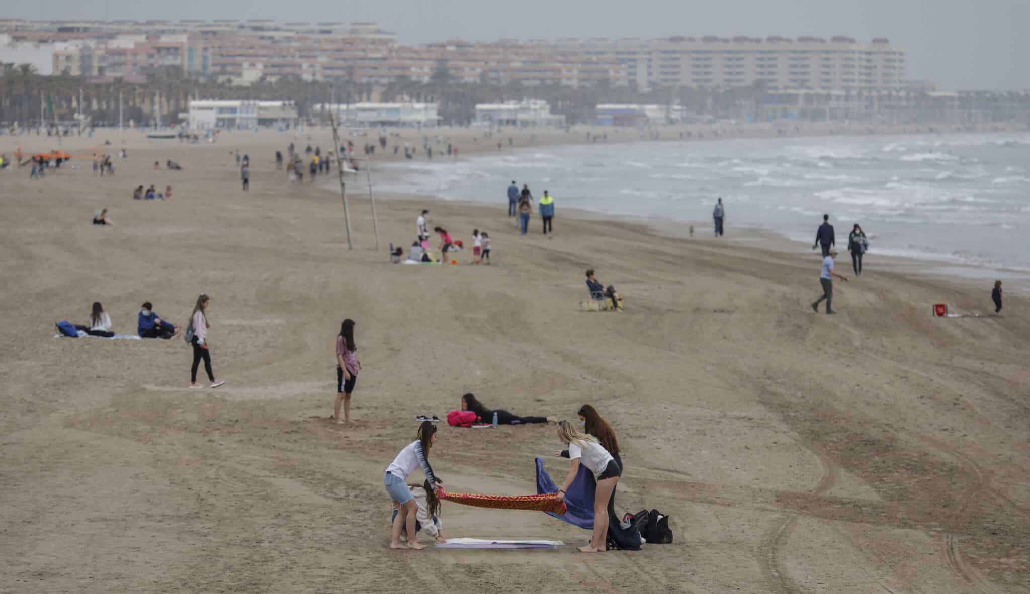 Varias personas en la playa la Malvarrosa en Valencia.
