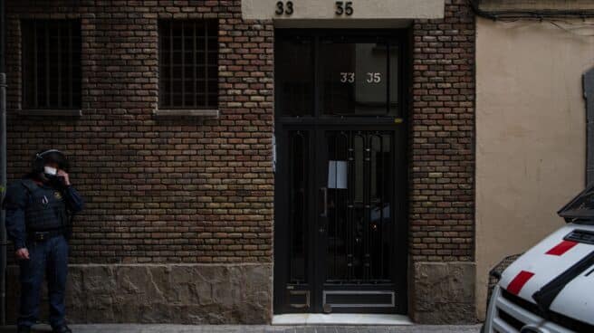 Un agente vigila la puerta del domicilio de un vecino de Barcelona que va a ser desahuciado.