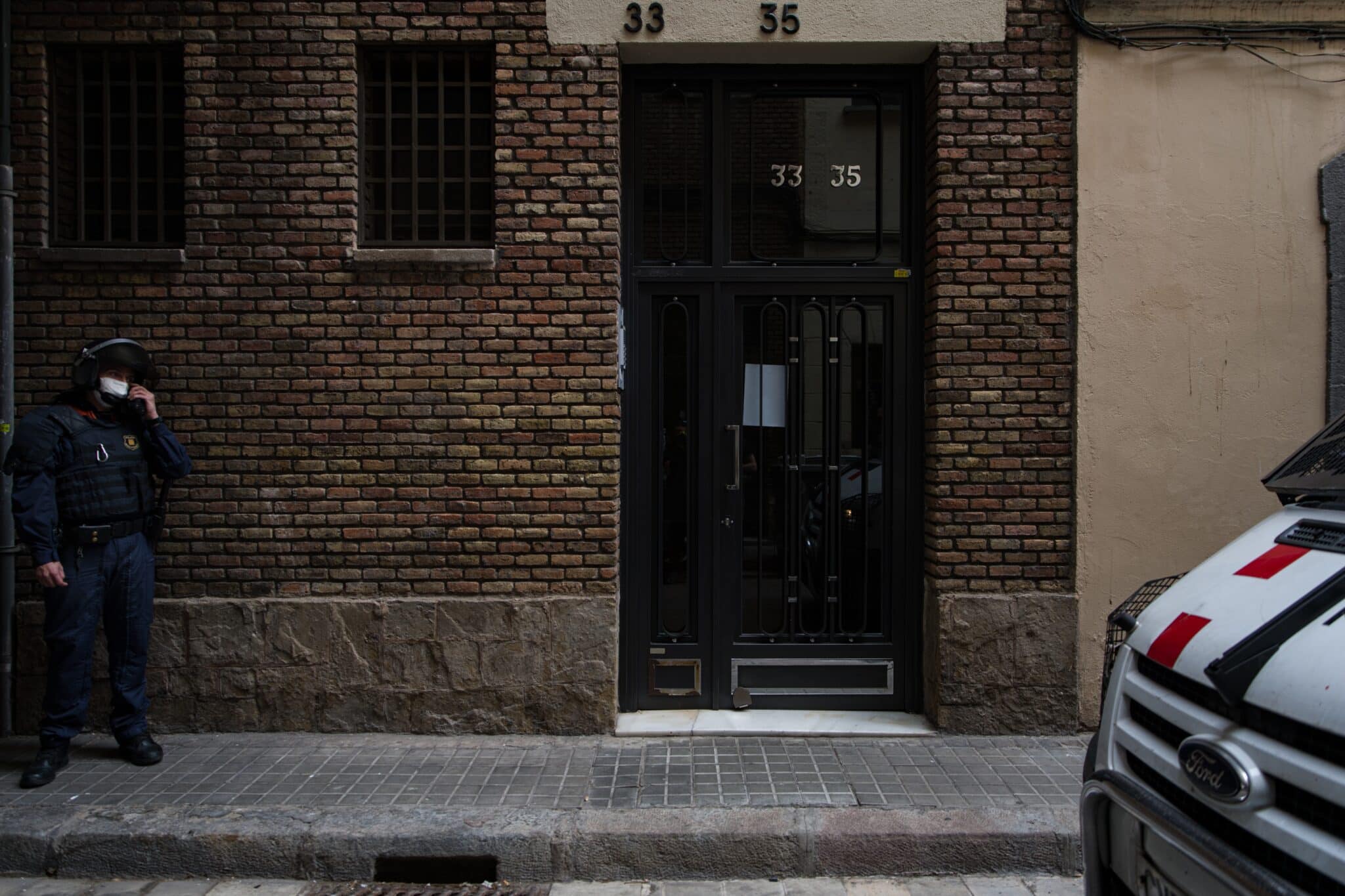 Un agente vigila la puerta del domicilio de un vecino de Barcelona que va a ser desahuciado.