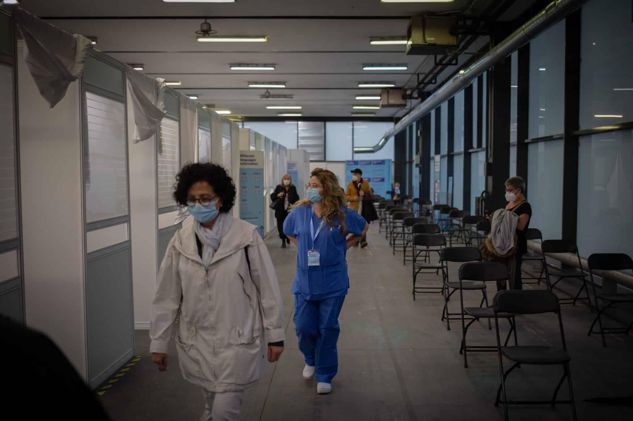 Una mujer y una sanitaria en el circuito de vacunación de Fira de Barcelona
