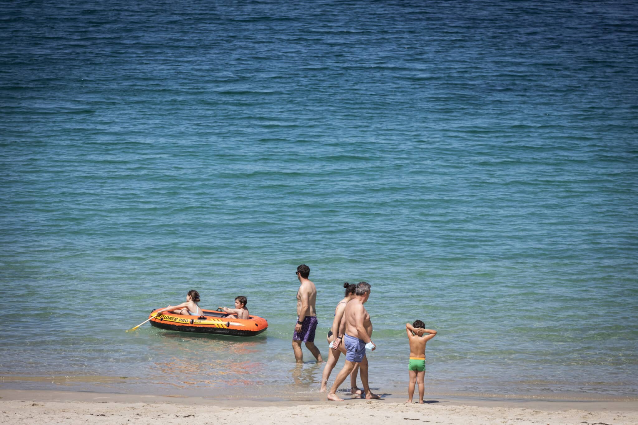 Varias personas se bañan y toman el sol en una playa del municipio de Marín, Pontevedra.
